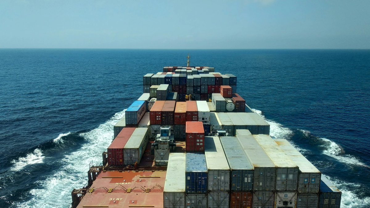 Container ship loaded with cargo containers sailing across the ocean